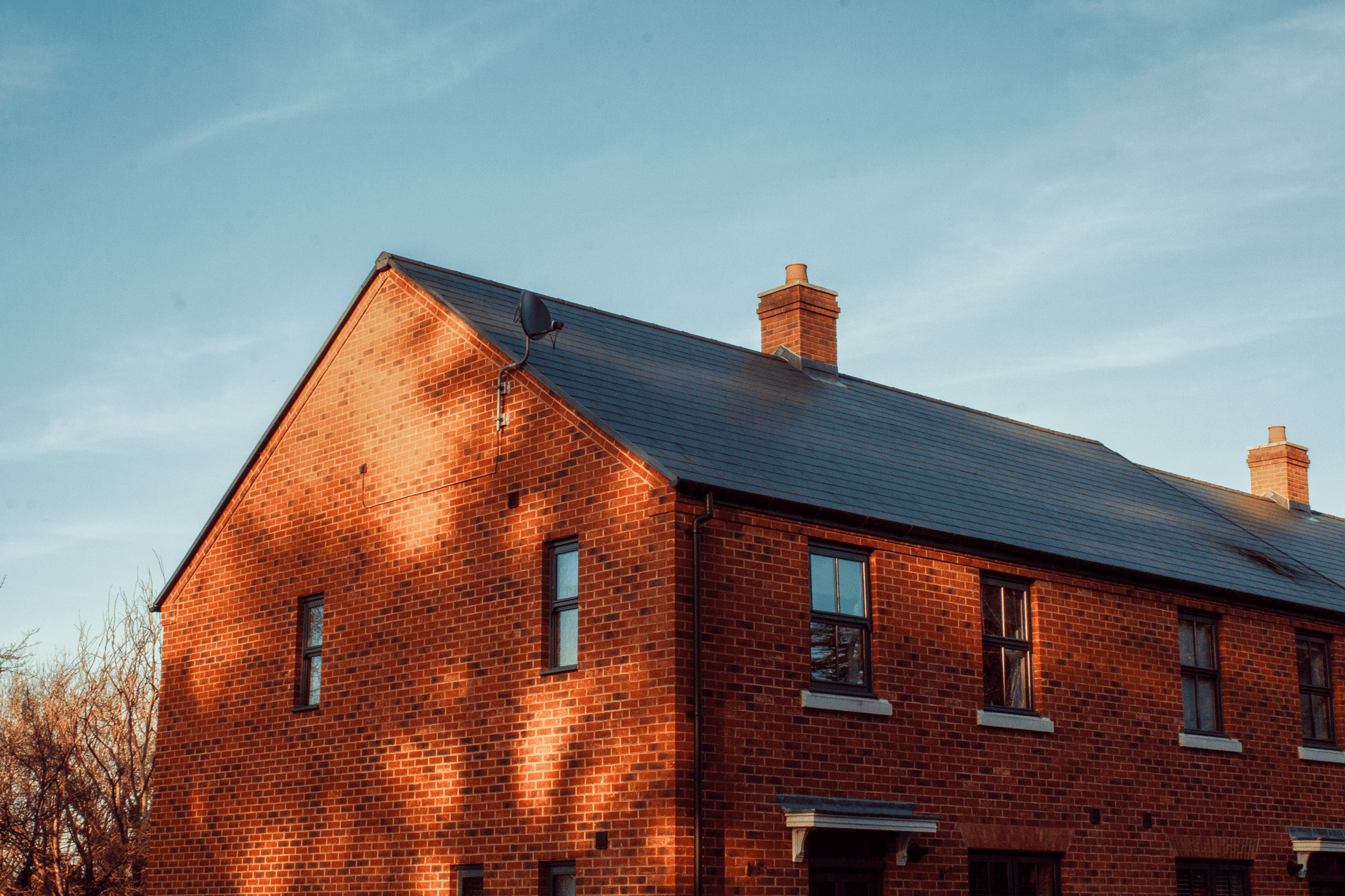 A traditional brick house in Shrewsbury, England, beautifully illuminated by the warm glow of sunset.
